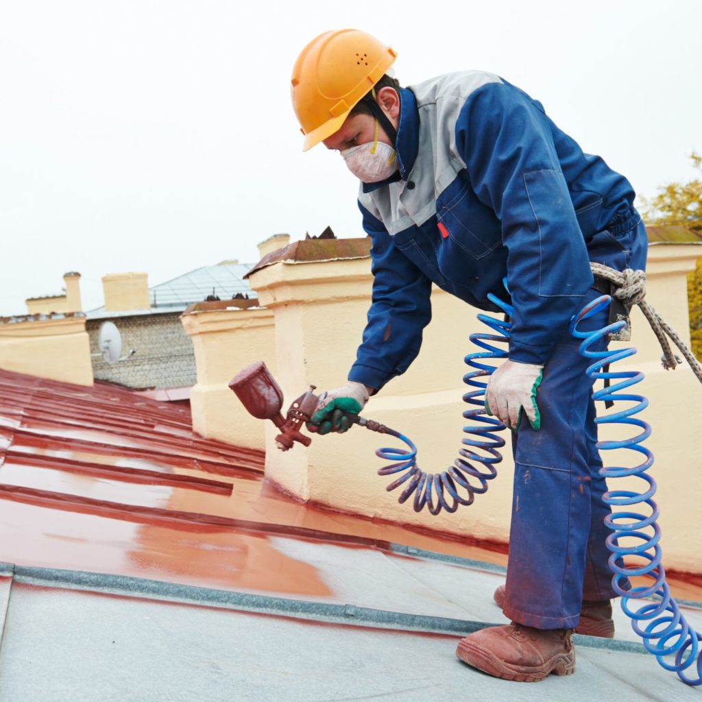 Man spraying a protective coating on a roof