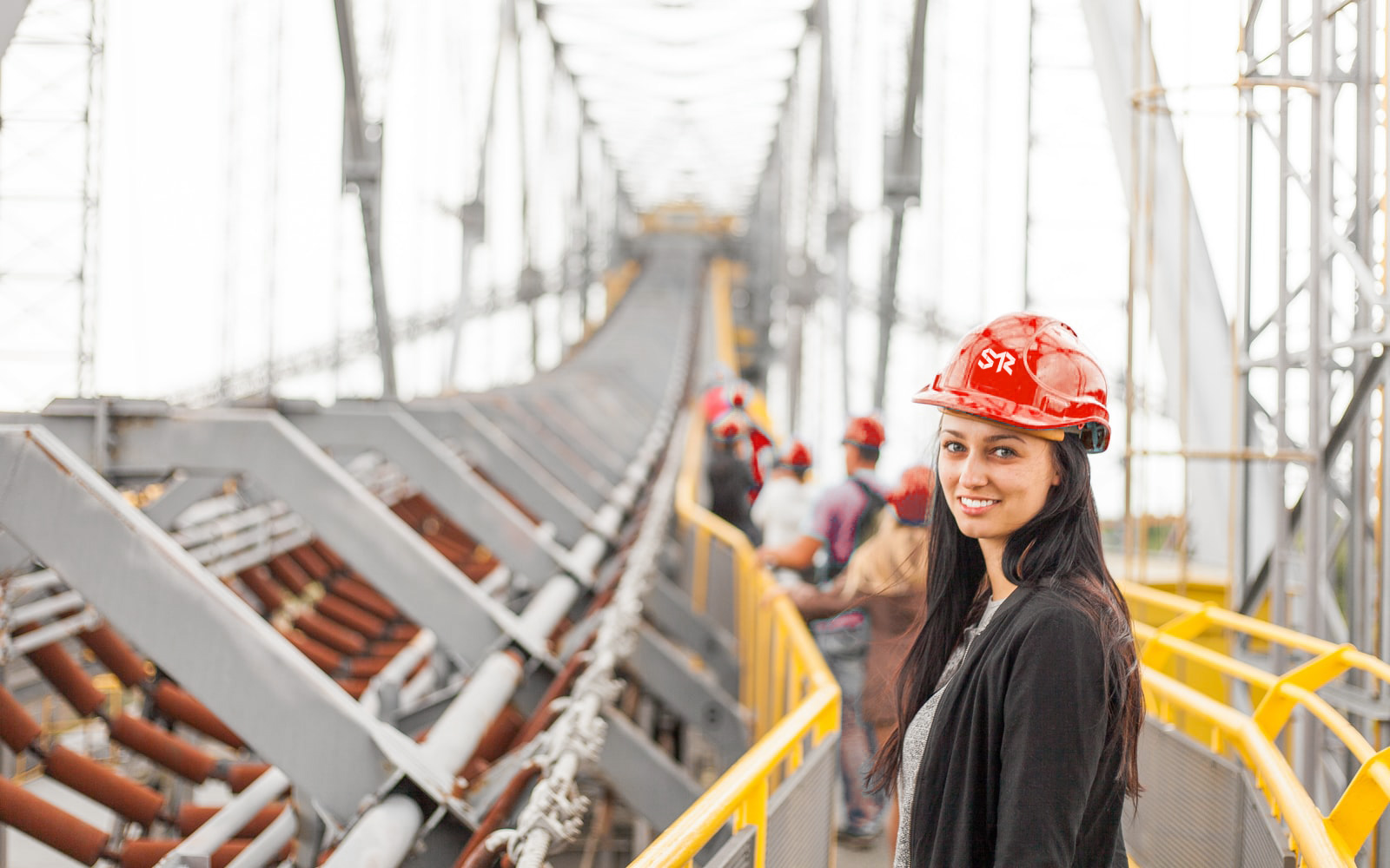 Woman with hard hat standing on a bridge being built