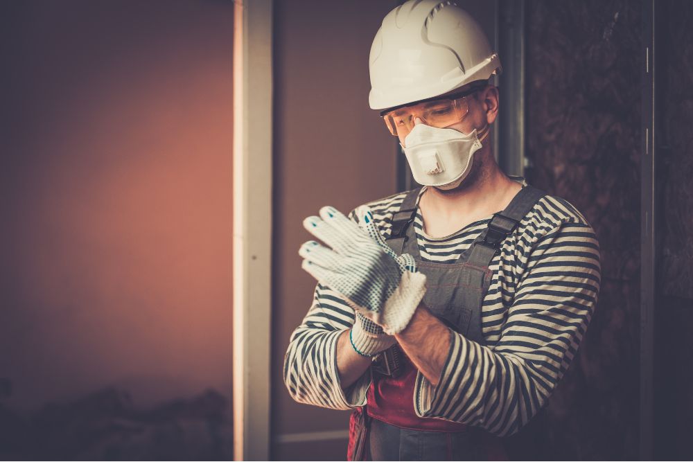 A remedial builder putting gloves on ready for work