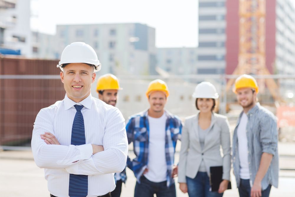 A remedial builder standing in front of a group of normal builders