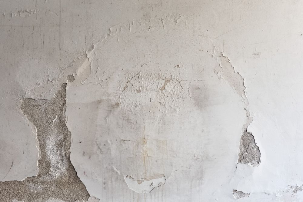Paint flaking on a wall due to moisture