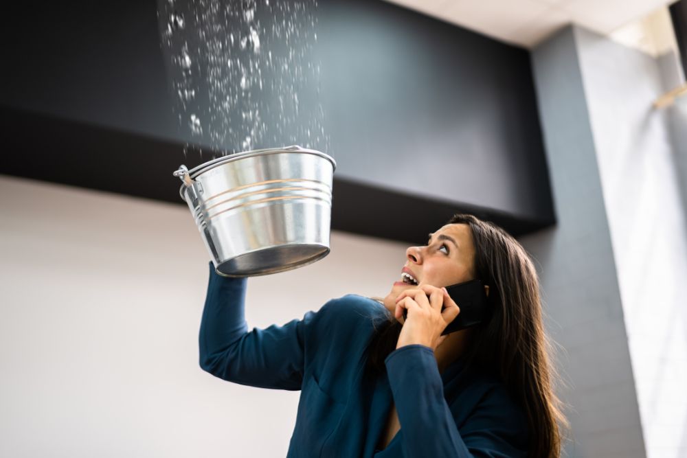 Water holding a bucket for water leaking from ceiling